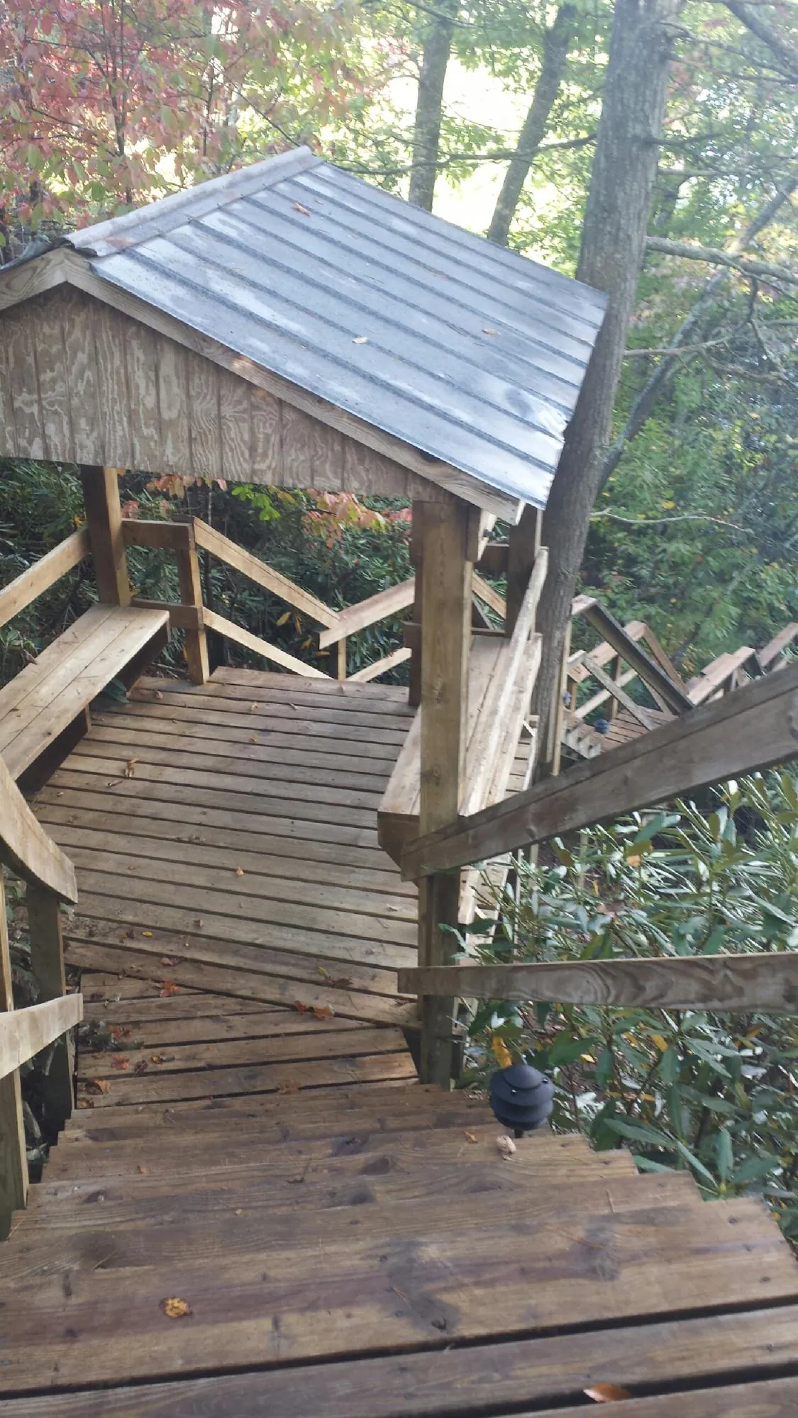 Metal roofed shelter over wooden steps on a wooded walkway — Skylight Repair & Installation work by our crew in Park Falls