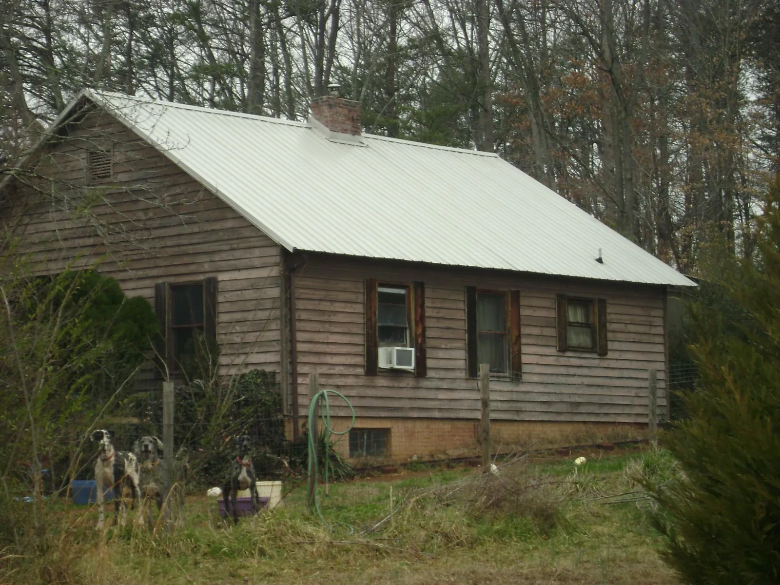 White metal roof on an old wood sided farmhouse, from a Metal Roof Installation job in Park Falls